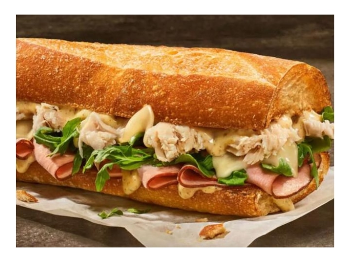 Chicken with ham, lettuce, and cheese on a crusty sub roll.