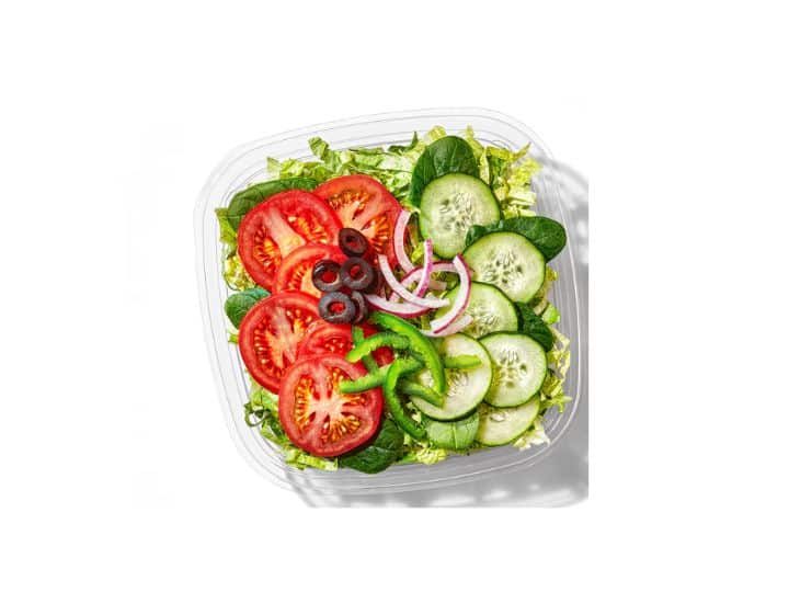 Tomatoes, cucumber, red onion, and green pepper on top of a salad.