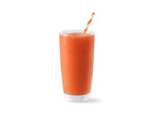 An orange smoothie in a glass cup.
