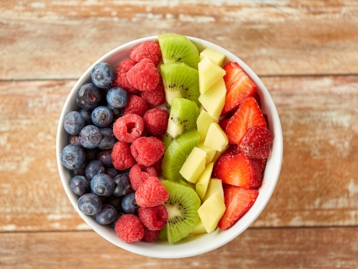 A bowl of blueberries, raspberries, kiwi, pineapple. and strawberries.