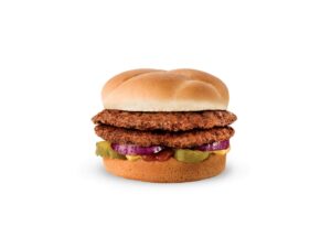A burger with two patties, ketchup, and onion.