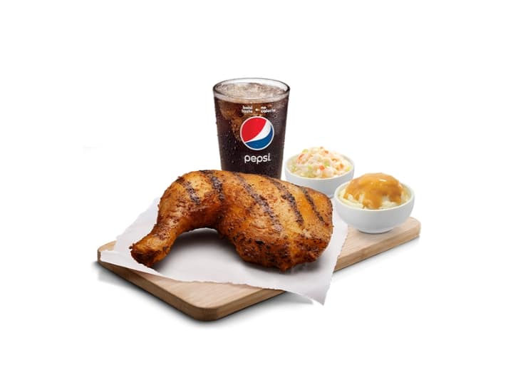 A grilled chicken wing, pepsi, mashed potatoes and gravy, and a bowl of coleslaw.