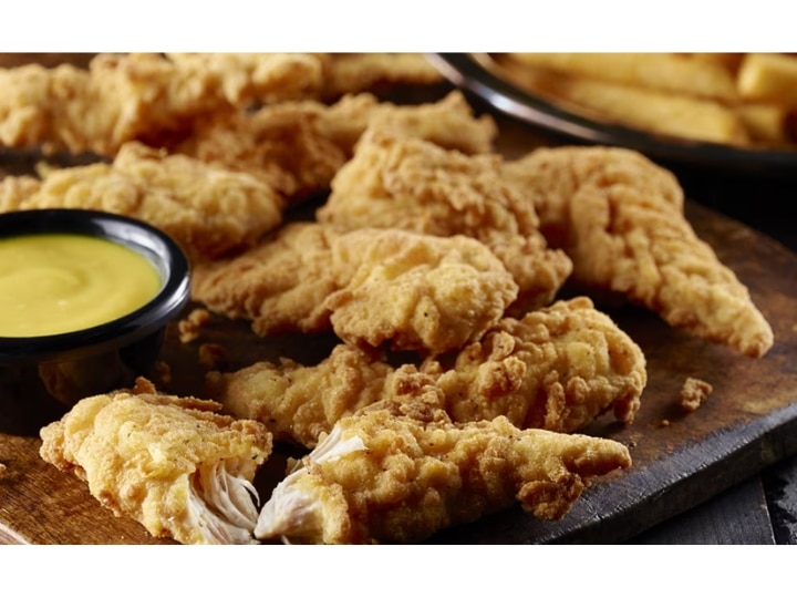 A bunch of chicken fingers on a plate.