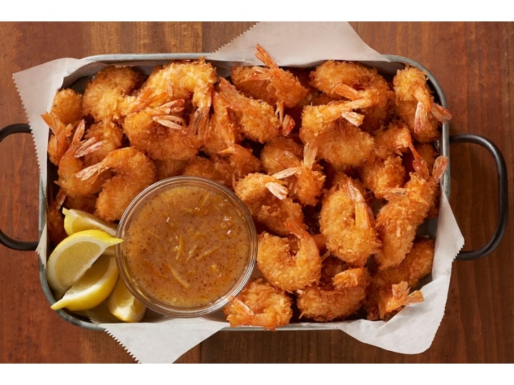 A bunch of coconut shrimp on a tray.