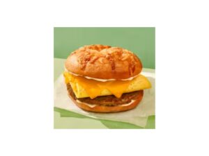 A sandwich with egg, cheese, and sausage on a asiago bagel.