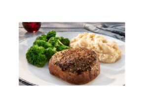 A piece of steak with broccoli and mashed potatoes on a white plate.