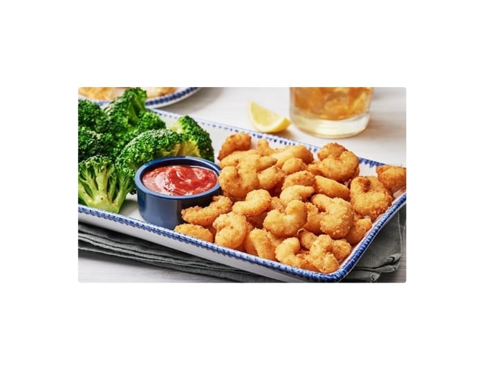 A bunch of popcorn shrimp on a plate.