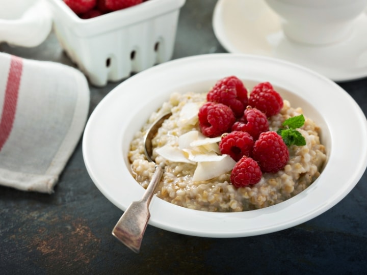 Raspberries on top of steel cut oats in a bowl.