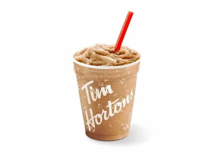 A clear cup with an iced capp in it with a red straw.