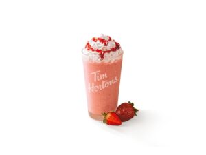 A bunch of whipped cream on top of a strawberry banana fruit smoothie.