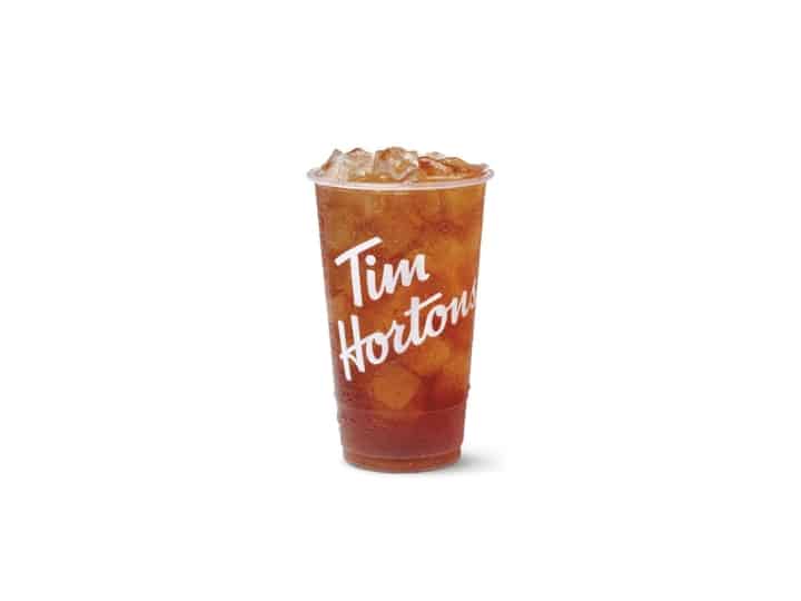 A sweetened iced tea in a clear cup.