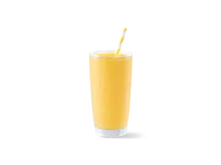 A mango smoothie in a glass cup.