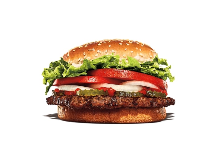 A hamburger with lettuce, tomato, and onion,