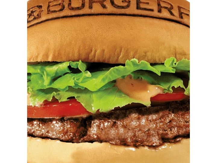 Part of a hamburger with lettuce and tomato.