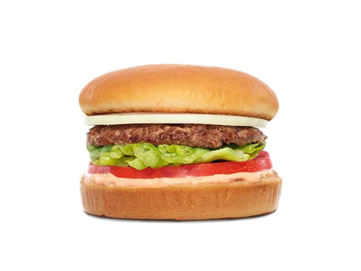 A hamburger with onion with lettuce, tomato, and sauce.