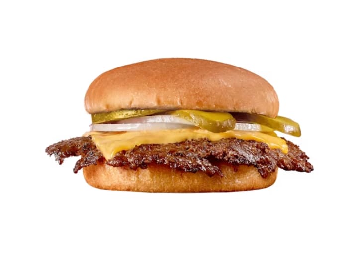 A burger with a thin patty, cheese, pickles, and onions.