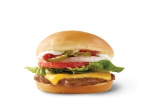 A burger with cheese, lettuce, onion, tomato, and pickles.