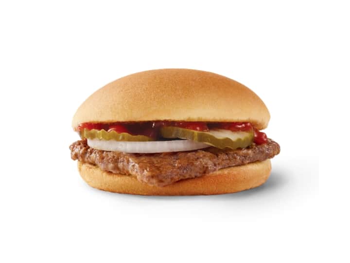 A hamburger with pickles, onion, and ketchup.