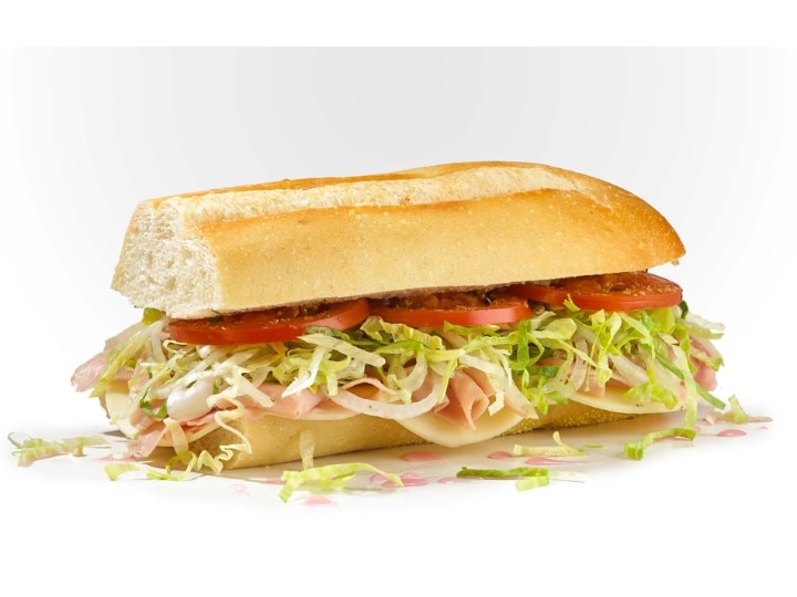 Half a sub with tomato, lettuce, turkey, onion, and cheese.