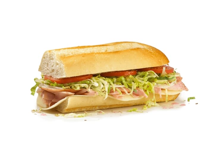 Half a sub with lettuce, tomato, turkey, ham, and cheese.