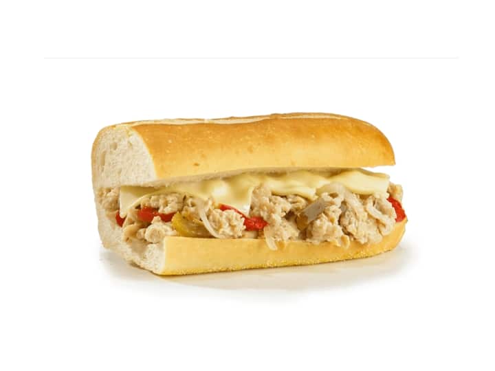 Half a sub with chicken cheesesteak, peppers, onions, and cheese.