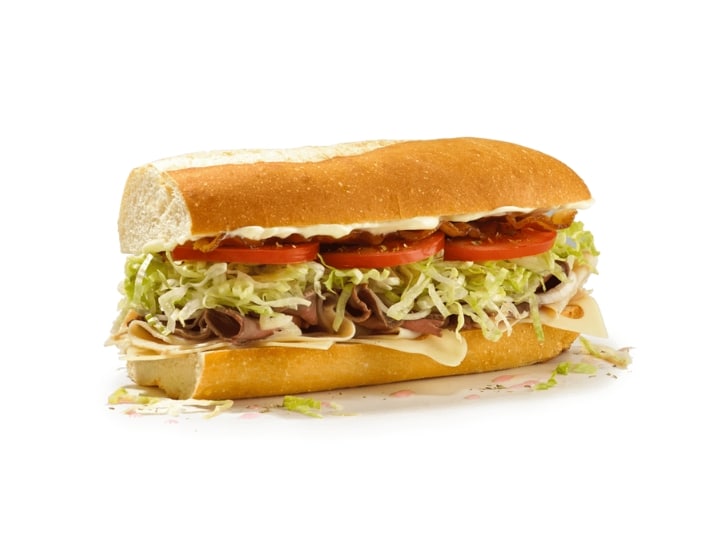 A sub with lettuce, tomato, roast beef, and cheese.