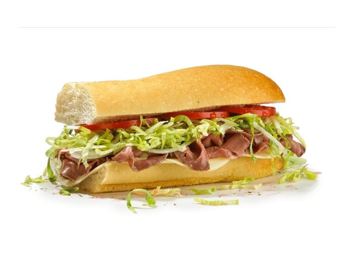 A sub with lettuce, tomato, roast beef, and provolone.