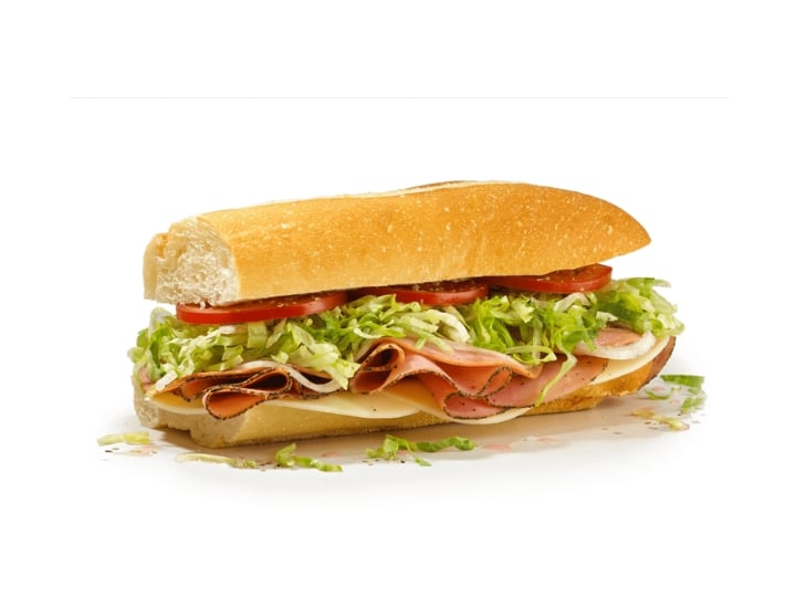 A subs with lettuce, tomato, ham, and cheese.