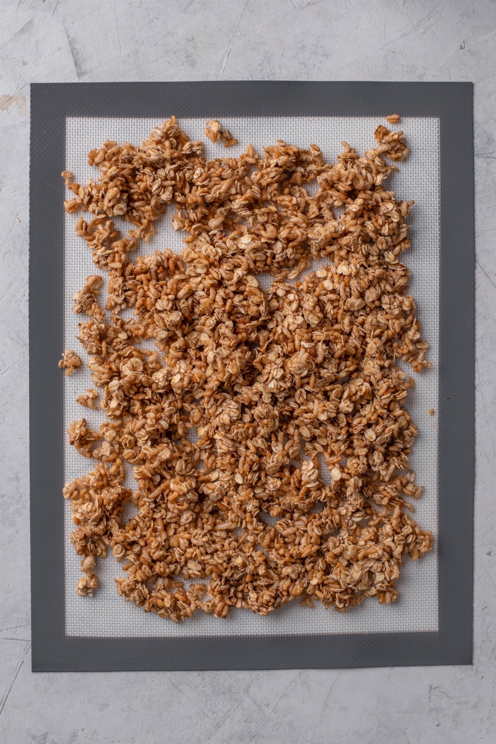 A silicone mat covered with an even layer of granola.