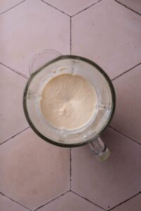 A blender filled with a creamy sauce.