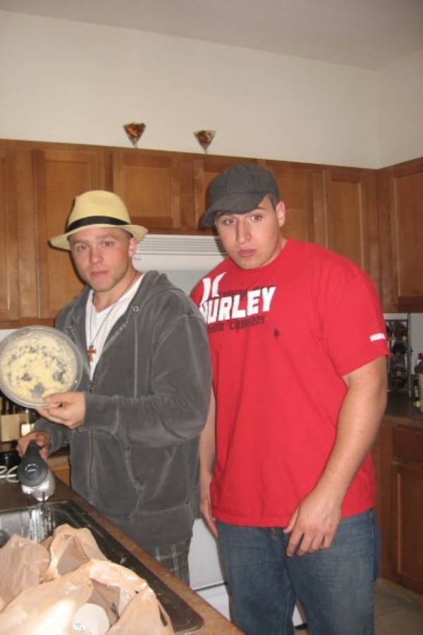 2 Men standing in a kitchen.