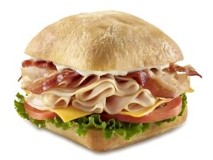 An image of a Tim Hortons turkey bacon club sandwich on a white background.
