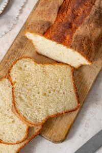 Top view of cottage cheese bread slices cut from a loaf on a cutting board.