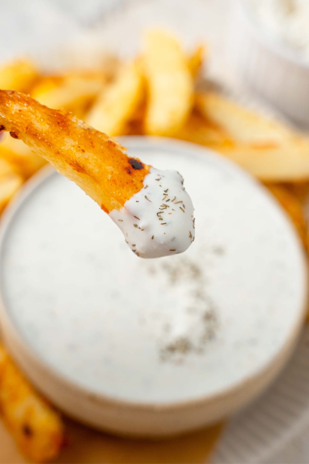 A seasoned fry dipped into cottage cheese ranch dip.