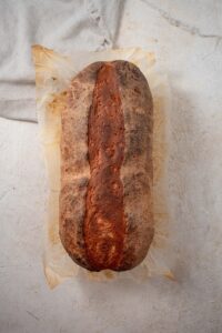 Top view of a cottage cheese bread loaf on parchment paper.