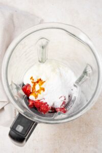 Strawberries, allulose, cream cheese, vanilla, and heavy cream in a blender.