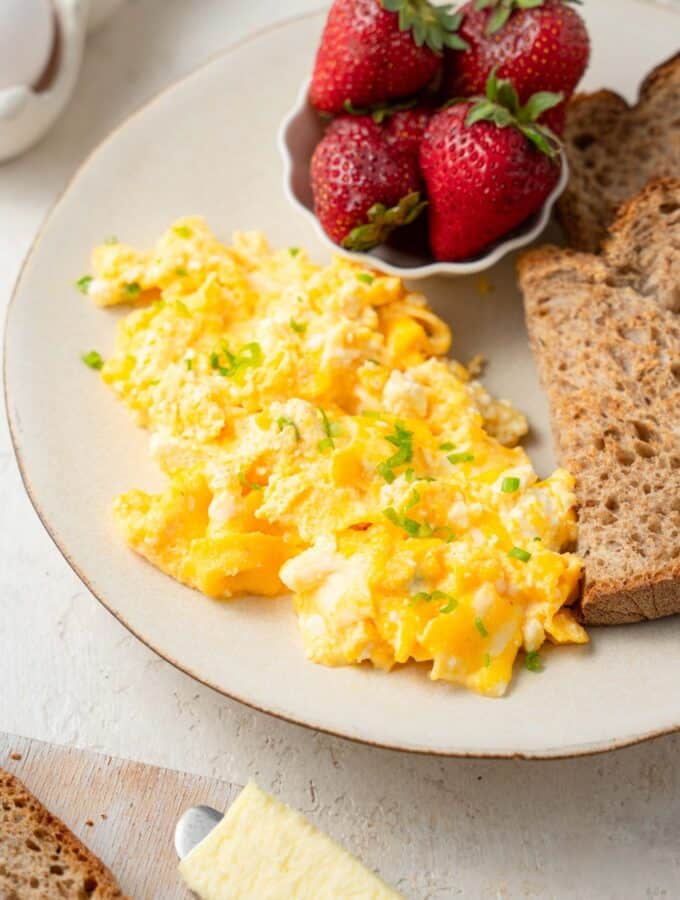 Cottage cheese omelet served on a plate with fresh strawberries and whole wheat toast.
