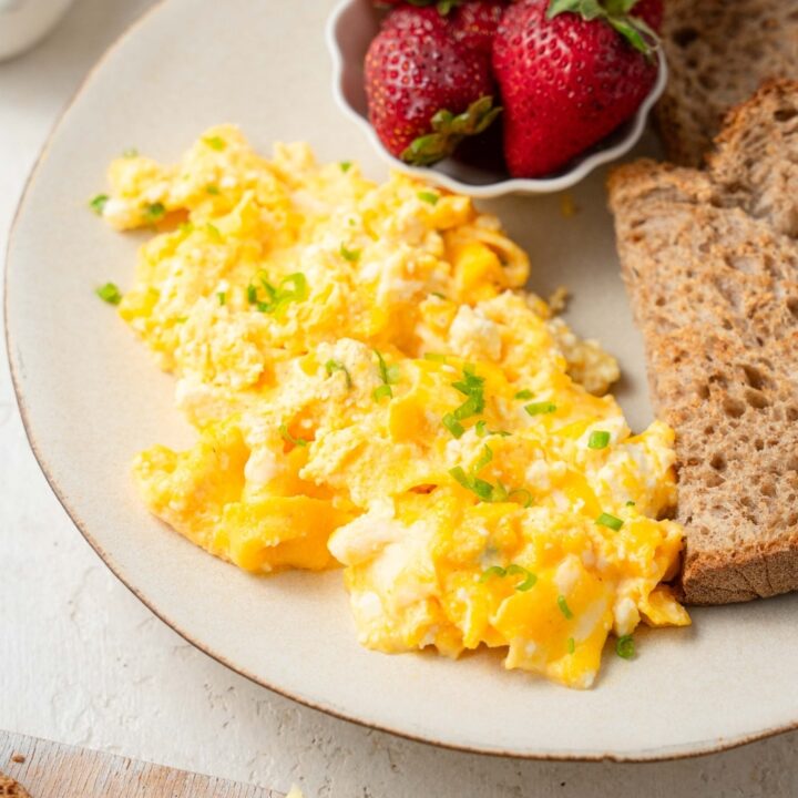 Cottage cheese omelet served on a plate with fresh strawberries and whole wheat toast.