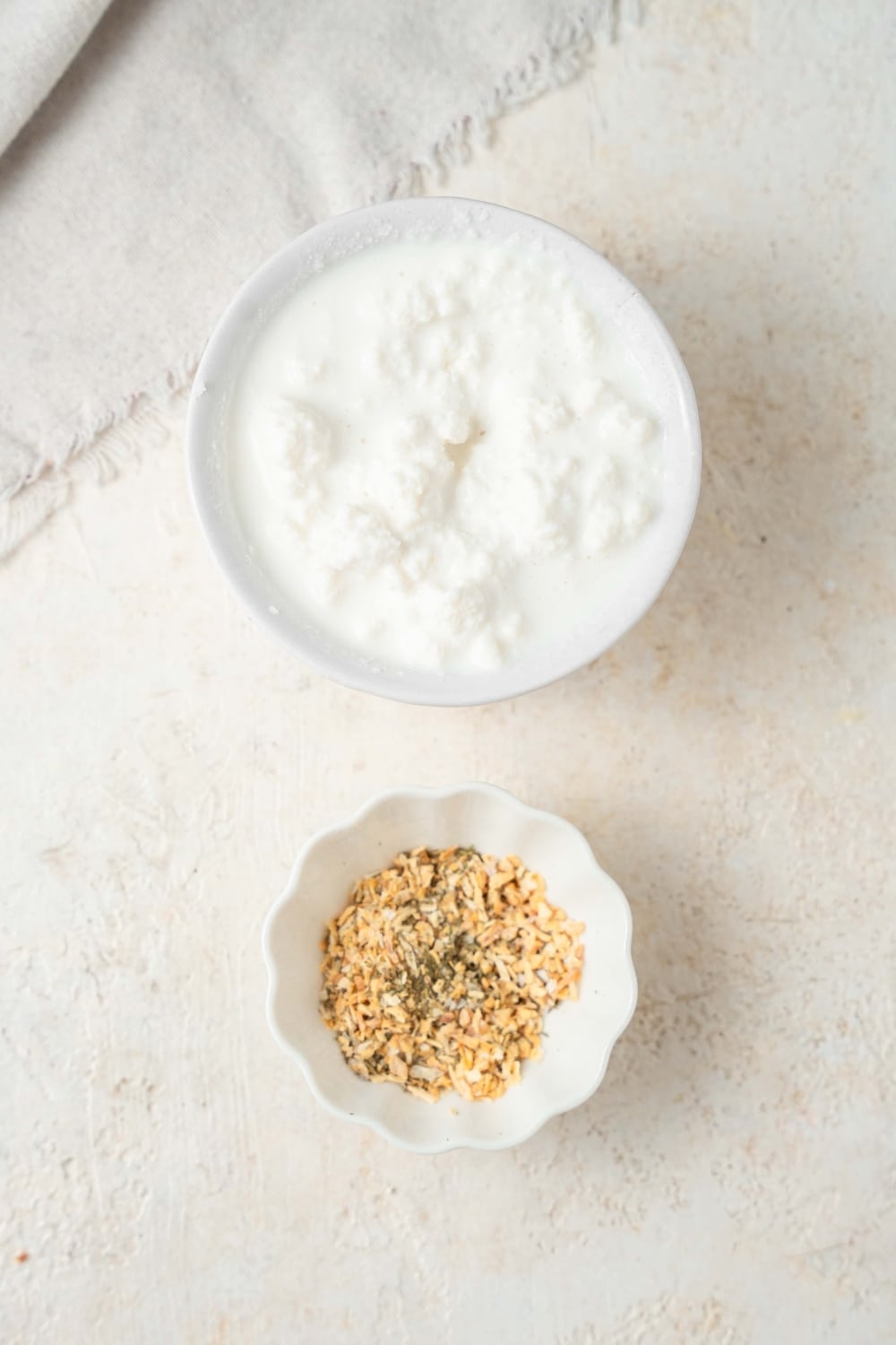 A bowl of cottage cheese and a bowl of ranch seasoning.