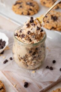 Scooping out cottage cheese cookie dough from a glass pot.