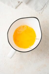 Whisked eggs in a ceramic measuring jug.