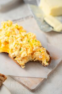 Cottage cheese omelet topped toast with a bite taken out.