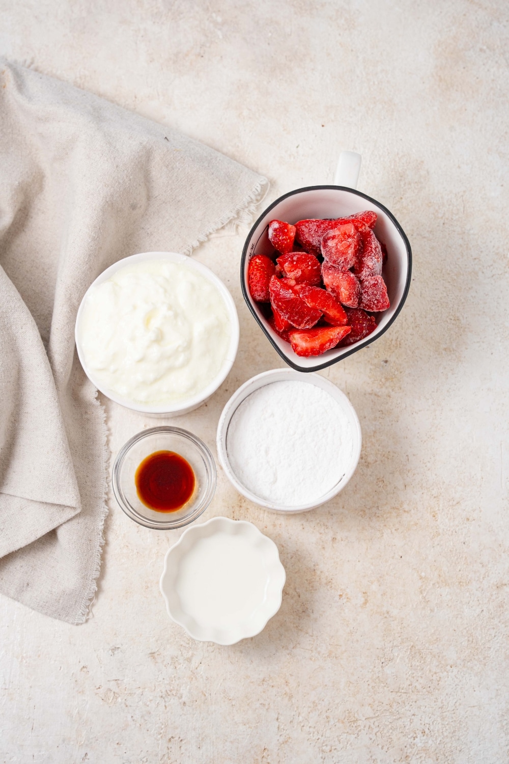 Bowls of frozen strawberries, cottage cheese, powdered allulose, vanilla extract, and heavy cream.