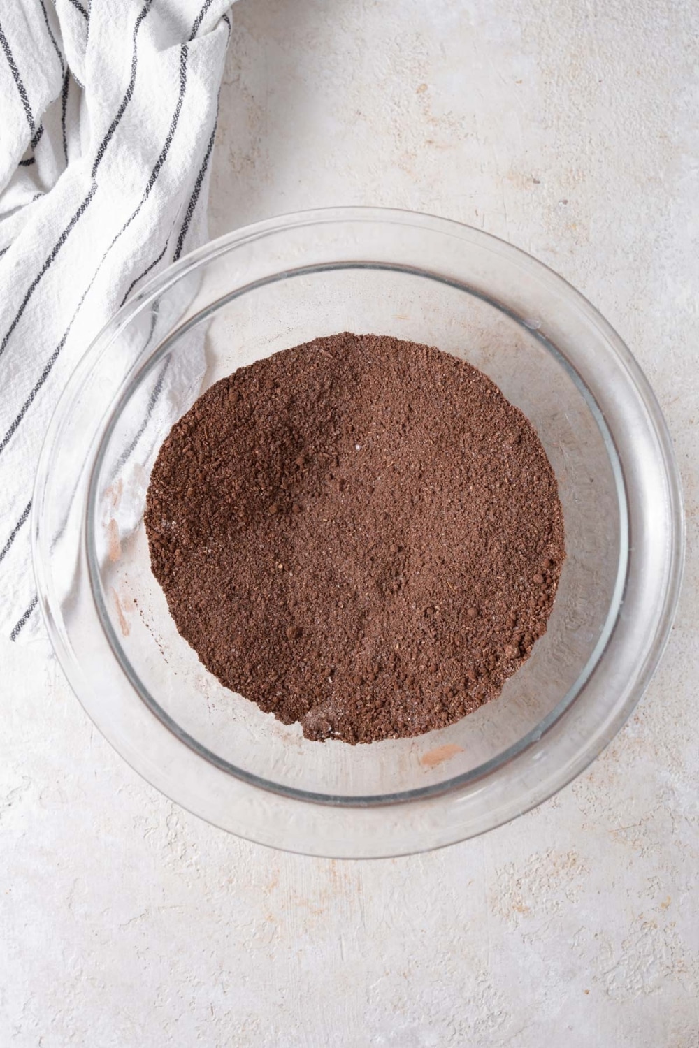 Dry ingredients for the cottage cheese brownie batter mixed in a glass bowl.