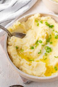 Scooping cottage cheese mashed potatoes with a spoon.