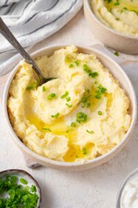A spoon scooping into a bowl of cottage cheese mashed potatoes.