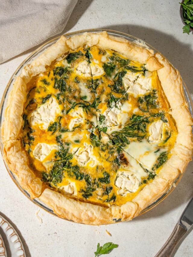 A spinach quiche with whipped cottage cheese topping, cut into 8 slices.