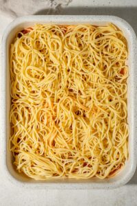 Cooked spaghetti in a casserole dish.