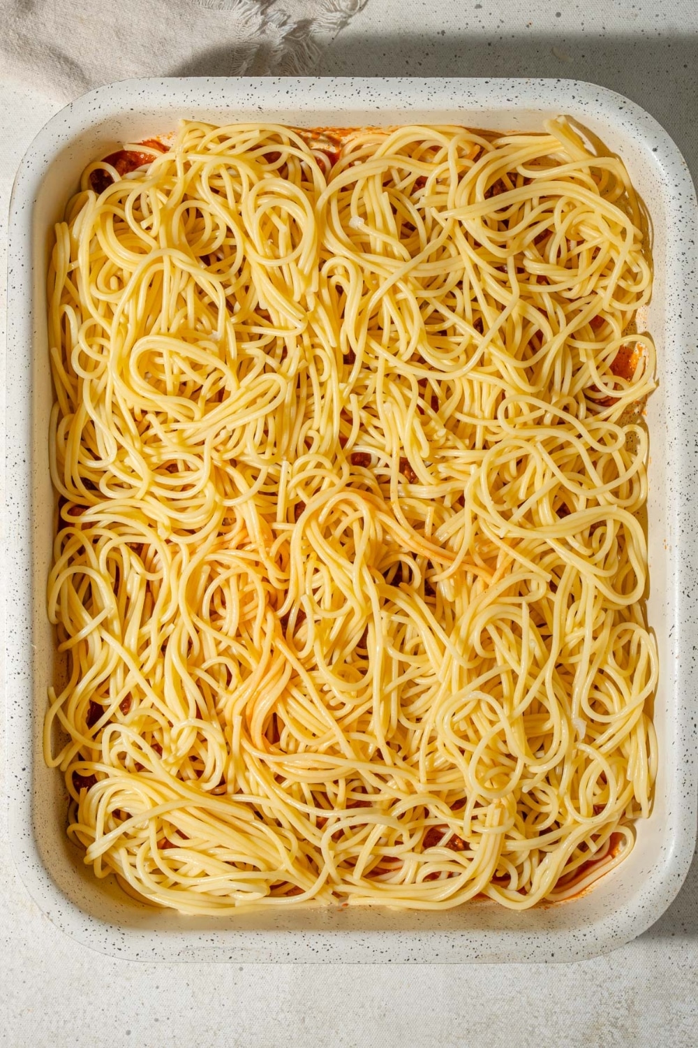 Cooked spaghetti in a casserole dish.
