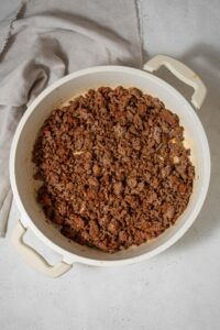 Seasoned ground beef in a white pot.